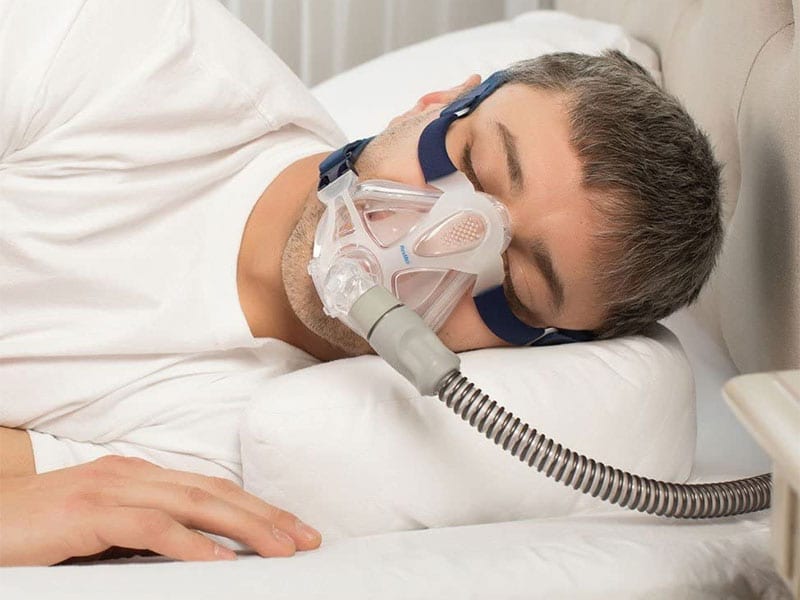 Best CPAP Pillows Man sleeping with pillow wearing cpap