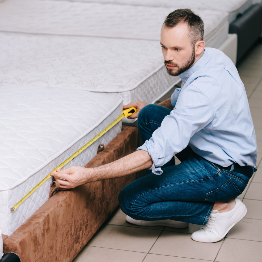 Queen Size Bed Dimensions Person measuring a queen size bed