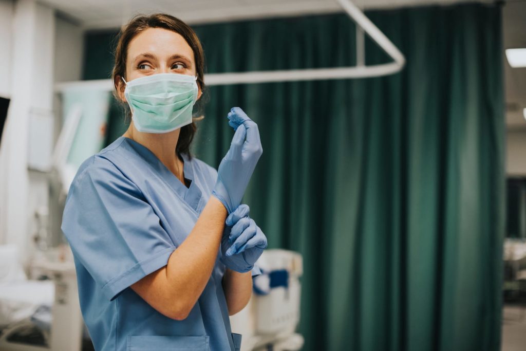 Shift Work Disorder Symptoms Female nurse with a mask putting on gloves